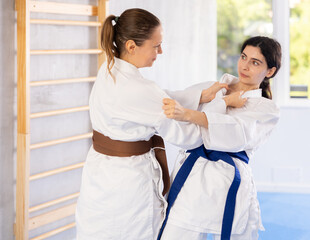 Fototapeta premium Karate practitioners showcase their techniques in dynamic sparring session, focusing on speed and accuracy.