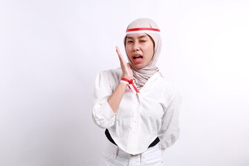 Happy expressive young Asian muslim woman is smiling, isolated on white background. Indonesian independence day concept
