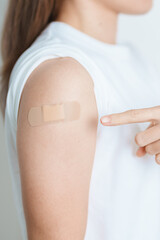 Woman with bandage after receiving vaccine. Vaccination and Immunization for Influenza, HPV,...