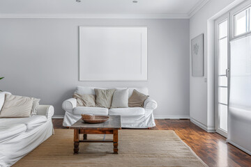 Bright minimalist living room in a luxury home with stylish minimal furniture and natural lighting. Home decor minimalist composition in neutral tonality.