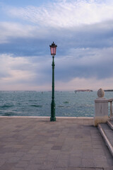 Seaside in Venice, street lamp. A lampstand on the promenade along the water.