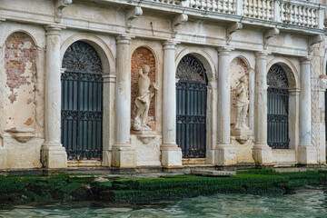 Grand Canal in Venice. Fragment of the building. Seaweed. Figures.