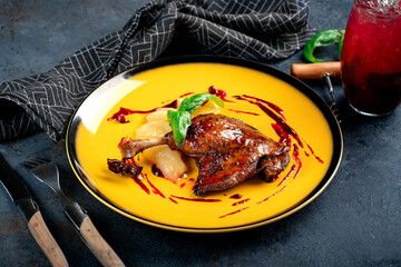 Duck cooked with a pear and served on a yellow plate with cranbe