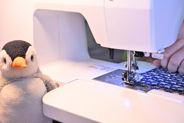 ミシンの台と針の間に布が挟まれている。ソーイングの準備。