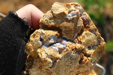 Sintered chalcedony on flint in hand. Searching for beautiful collectible stones, rockhounding