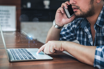 Man talking on phone and using laptop with digital security interface, illustrating remote work and cybersecurity.