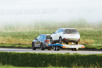 Fototapeta premium Tow truck towing cars along highway