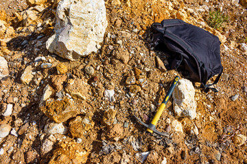 A pickaxe and a backpack lie surrounded by stone fragments, searching and collecting collectible...