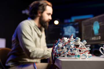 Focus on EEG headset used by engineer in blurry background to upload consciousness into computer....