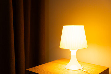 Lamp on table of bedside, Interior of the bedroom, warm light for background.