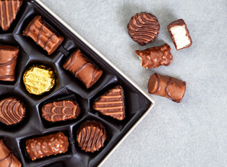 Box of assorted chocolates, abstract crop on grey with copy space 