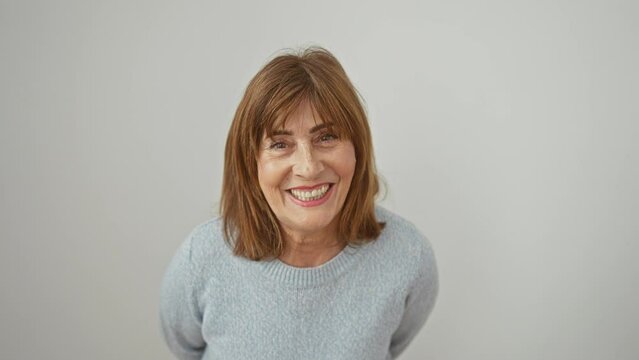 Hilarious middle age woman with short hair, confidently wearing sweater, making a funny face by puffing cheeks full of air. crazy expression over an isolated white background.