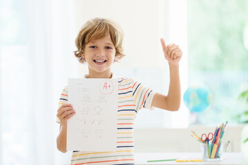 Child holding school test with excellent A grade.