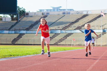 Fototapeta premium Child running in stadium. Kids run. Healthy sport.
