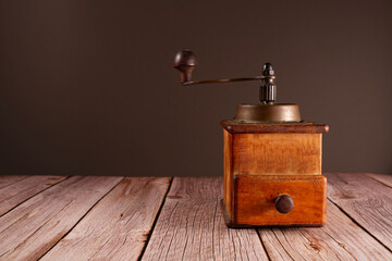 Coffee Cup and vintage coffee grinder on brown background