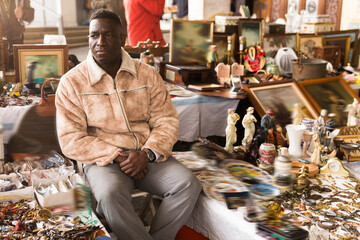 Ordinary african american guy sells things at a flea market