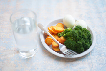 A breakfast diet plate without rice, featuring eggs, carrots, and broccoli, promoting a healthy and balanced meal