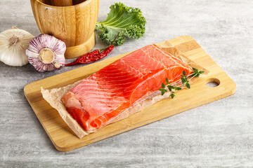 Raw salmon fillet over board