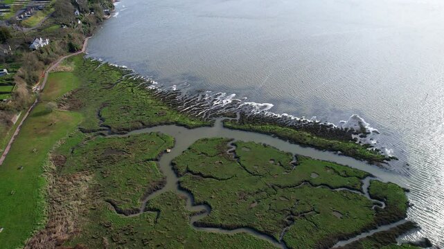 Wetlands of River Coran on ocean coast in Laugharne, Carmarthenshire, Wales. Aerial parallax