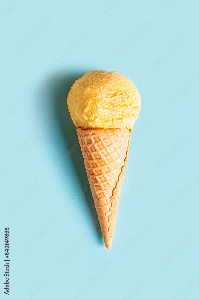 Wall mural yellow ice cream cone on blue background