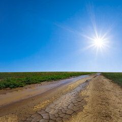dirty ground road among green prairie at summer sunny day