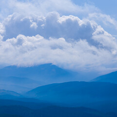 Obraz premium mountain ridge silhouette in mist and dense clouds
