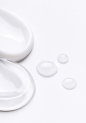 samples of cosmetic care products smear of cream and gel texture on a light background