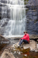 beautiful mature women against the backdrop of the largest waterfall in the Southern Urals, Gadelsha waterfall