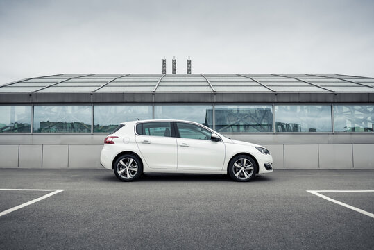 Kyiv, Ukraine - September 21 2015: white Peugeot 308 hatchback in front of glass pavilion. side view of compact car