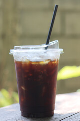 Black coffee with ice on table in cafe.