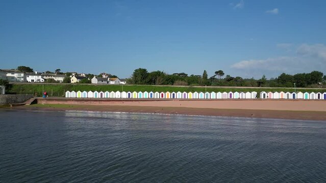 Goodrington Sands, Torbay, South Devon, England: DRONE VIEWS: The drone zooms in to a row of colourful beach huts on the seafront. Torbay is a popular UK holiday destination (4).