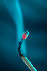 Smoke from an extinguished match on a dark turquoise background. Macro. Close-up. Match. 