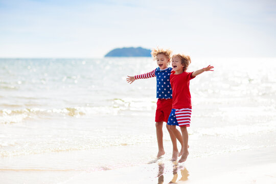 Kids with American flag on beach. 4th of July.