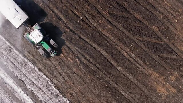 Aerial View Of A Tractor Pouring Lime Into The Soil To Neutralize The Soil Acidity.