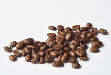 Close up photograph of the roasted coffee beans on white background with copy space. 