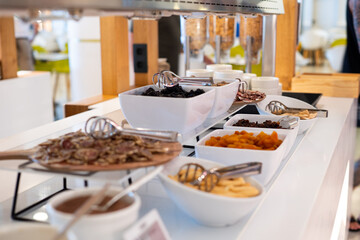 A buffet table with a variety of food items, including bowls of fruit and nuts. The table is set up in a restaurant or cafeteria setting