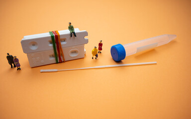 Covid-19 rapid antigen test cassettes (tied with rubber bands) with swab stick, test tube and human...