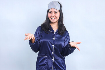 Young Asian Woman Wear Pajama And Eye Mask Open Both Hands Welcoming Or Showing Greetings Gesture