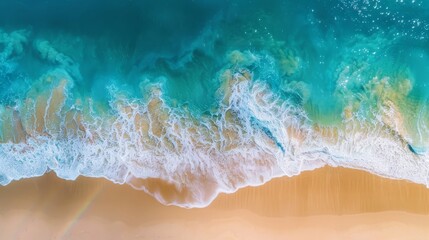 Vibrant shoreline seen from above, waves gently kiss the sand