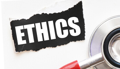 ETHICS on a small piece of paper next to a stethoscope.