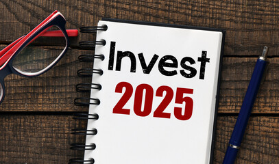 Invest 2025 words written in an office notebook. Concept for business.