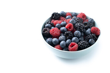 Fresh assortment berries in bowl isolated on white background. Copy space