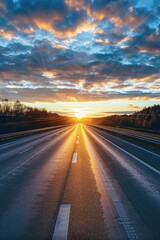 Naklejka premium A quiet road stretches out as the sun sets behind, creating a warm orange glow