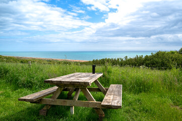 Fototapeta premium Wooden bench at Cogden beach overlooking Chesil beach stretch on the Jurassic Coast World Heritage Site, Dorset