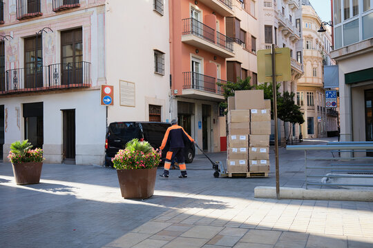 Man delivering cardboard boxes in the city