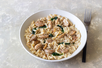 Orzo pasta with mushrooms and spinach. Italian Cuisine. Vegetarian food.
