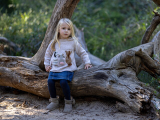 Blonde cute toddler in the forest