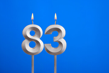 Birthday number 83 - Candle lit on blue background
