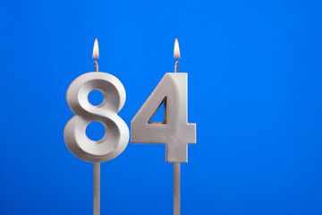 Birthday candle number 84 - Celebration card on blue background