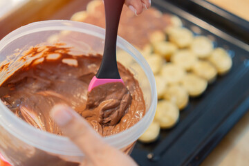Decoration, baker or cook with a small business concept. Woman hand baking and cake with chocolate in a kitchen.